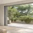 Fenêtre aluminium à galandage ouverte sur une terrasse